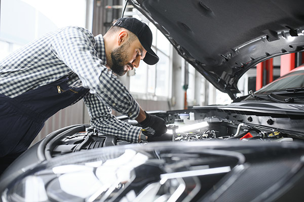 mechanic-examining-under-hood-of-car-at-the-repair-2024-05-02-21-24-57-utc.jpg